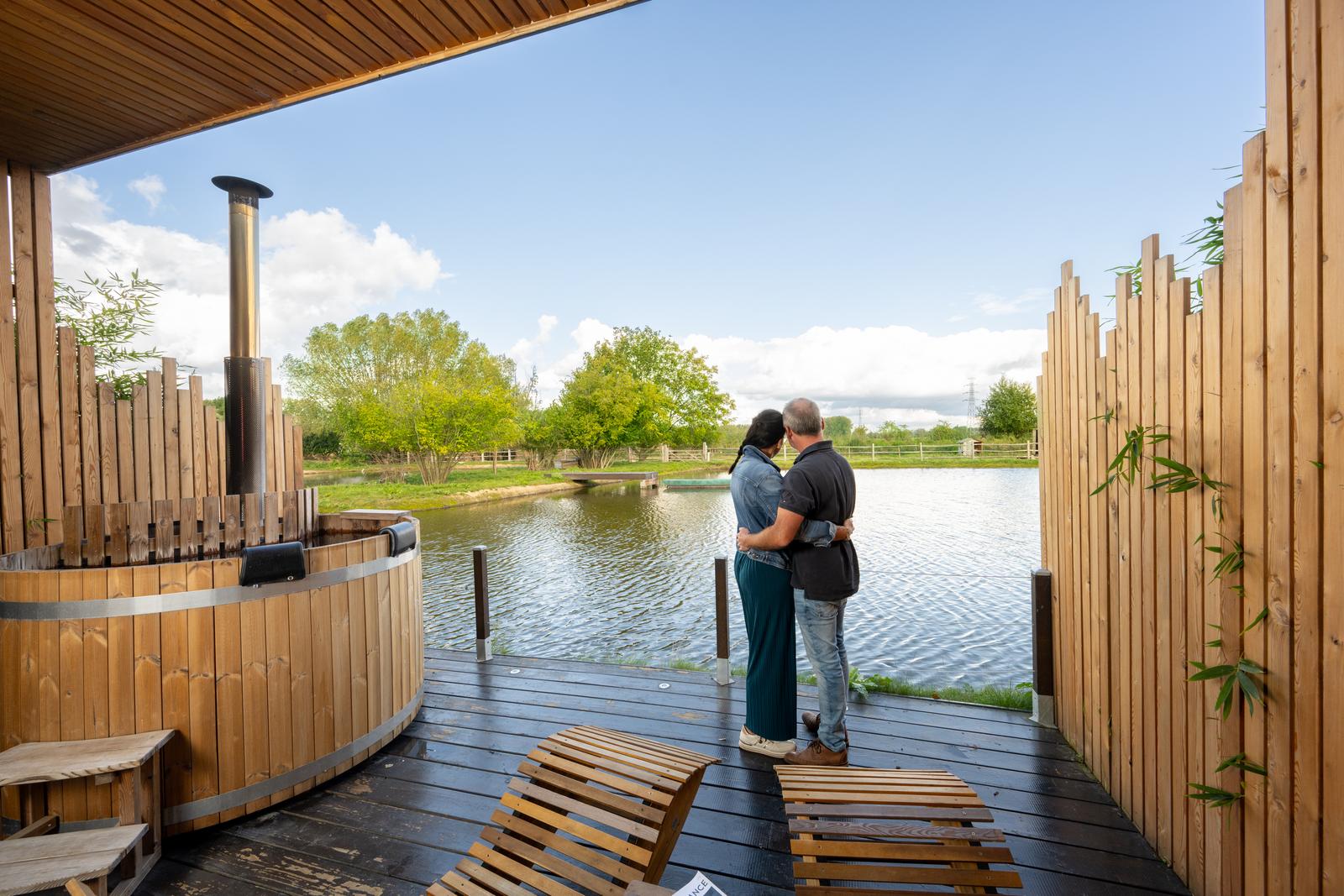 Le Domaine de Wambrechies : couple face à l'eau sur la terrasse du lodge so chic