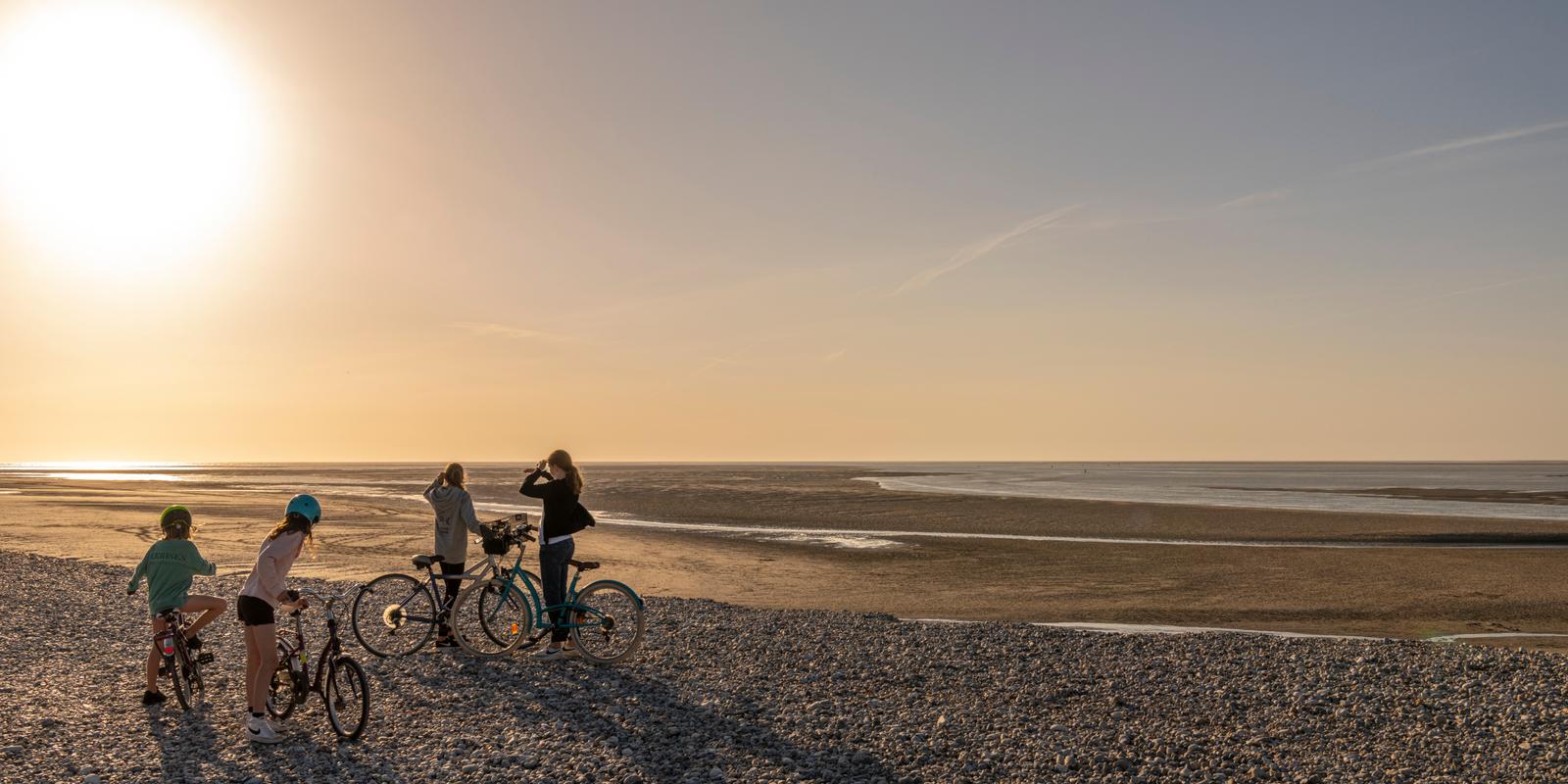 Le Hourdel : enfants à vélo sur la plage au soleil couchant