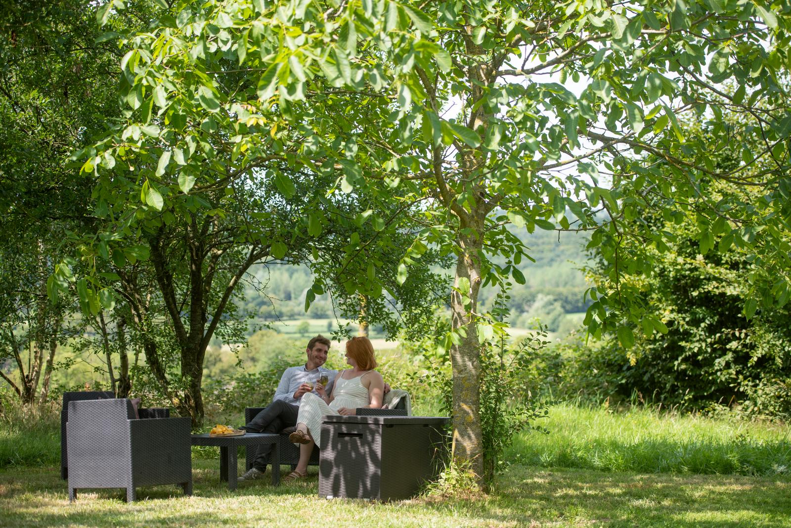Etréaupont : couple prenant l'apéritif sous un arbre au domaine des Foulons